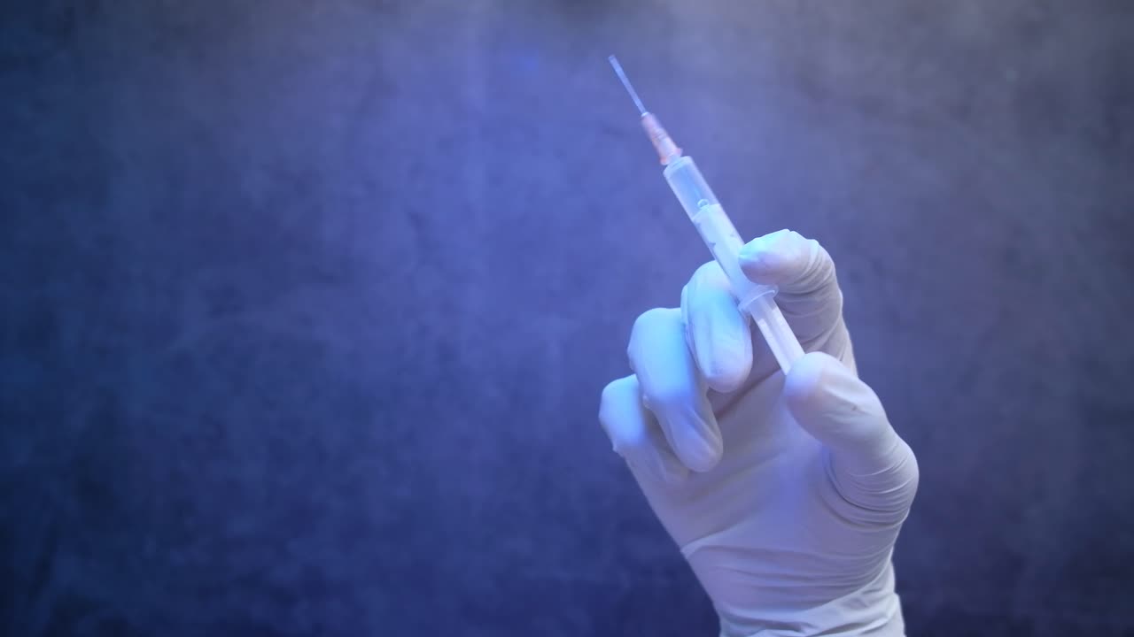 en guante de mano con una jeringa