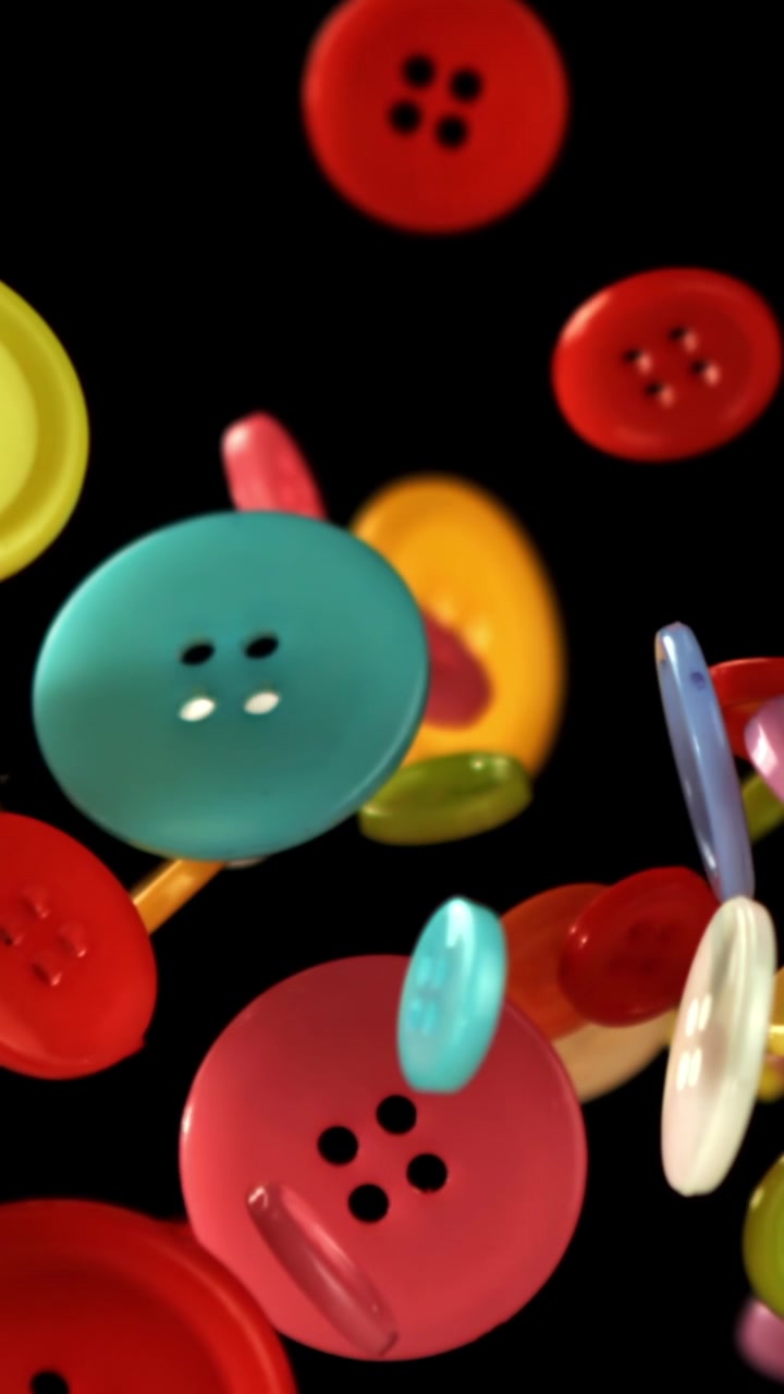 Colorful Sewing Buttons Falling in Slow Motion on Black Background