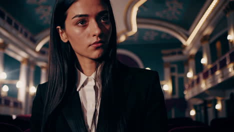 woman in a suit at a theatre