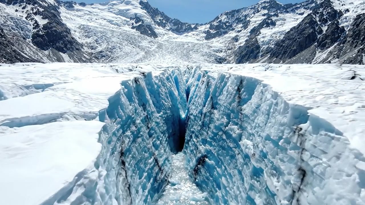 Stunning Glacial Landscape Revealing Crystalline Ice Formations Amidst Majestic Snow-Capped Mountains Under Clear Blue Skies in a Remote Wilderness Area