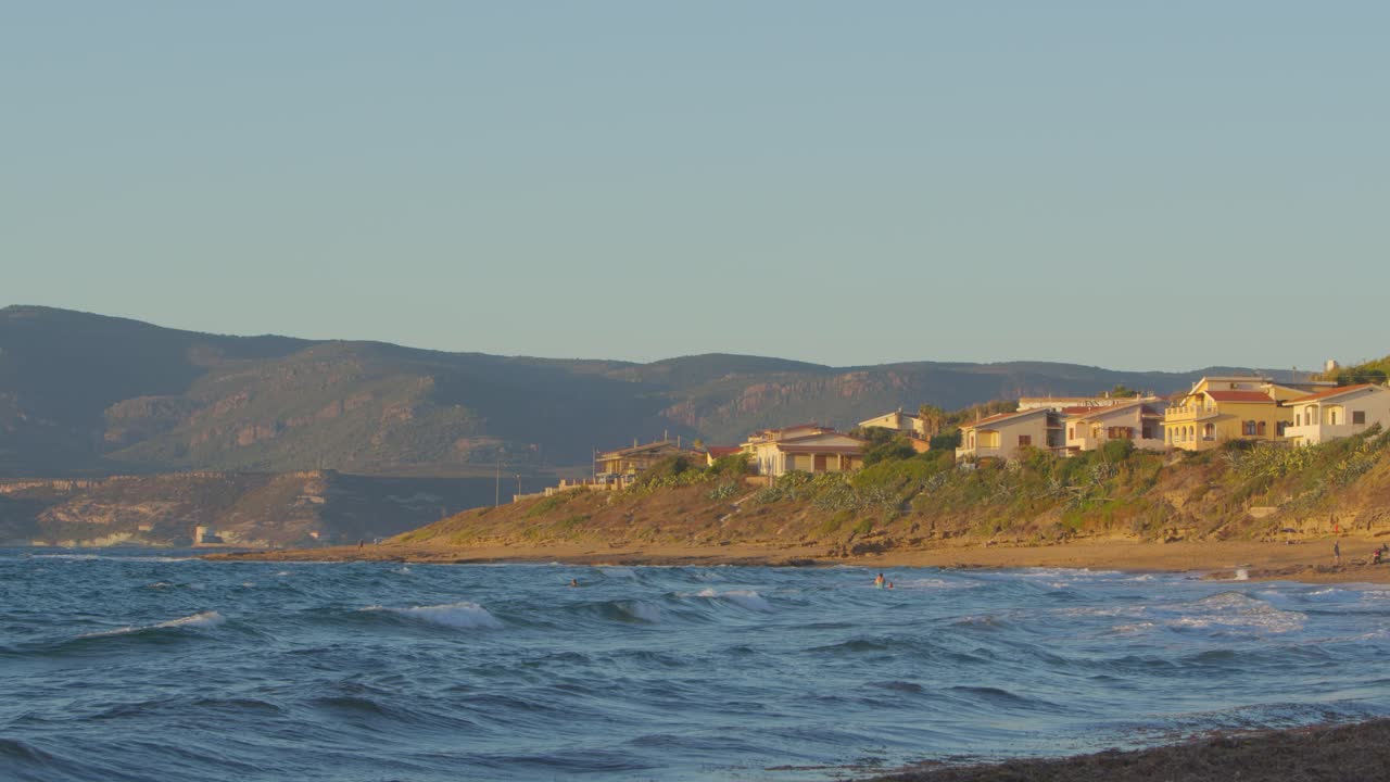 majestuosas olas del mar golpeando la costa de porto alabe en italia, vista estática de la hora dorada