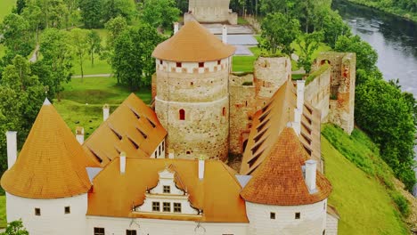 cinematic aerial over historic bauska castle using 70mm lens in dramatic light