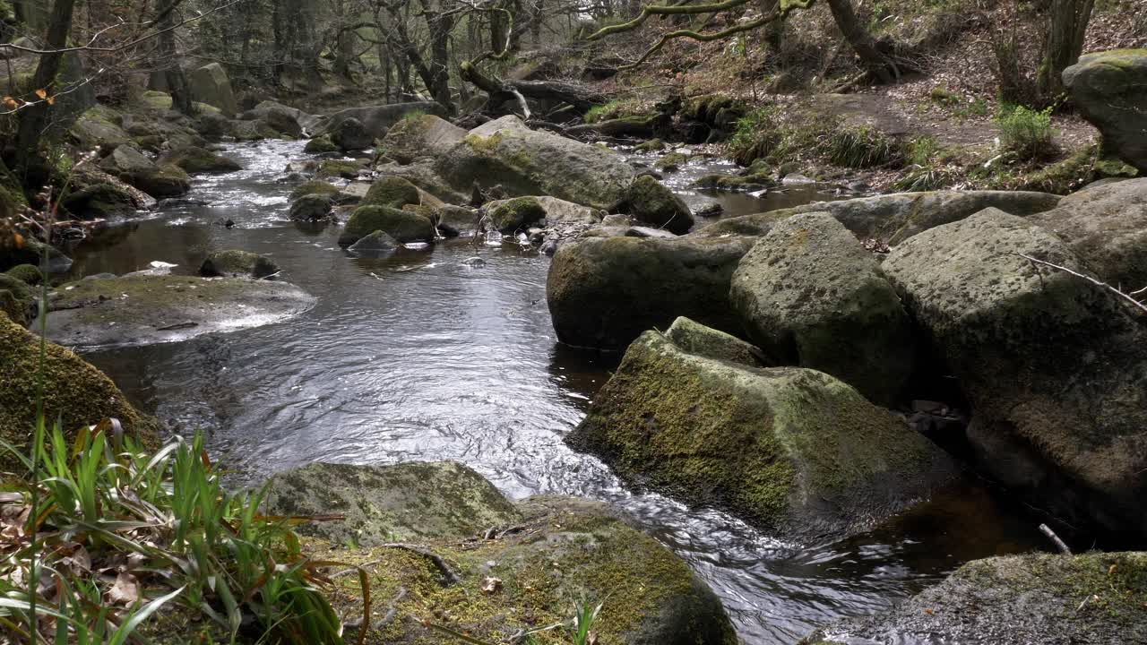 Water gently flowing over rocks on Burbage Brook at Padley Gorge in Derbyshire