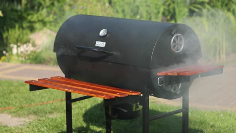 parrilla de barbacoa fumando en el jardín