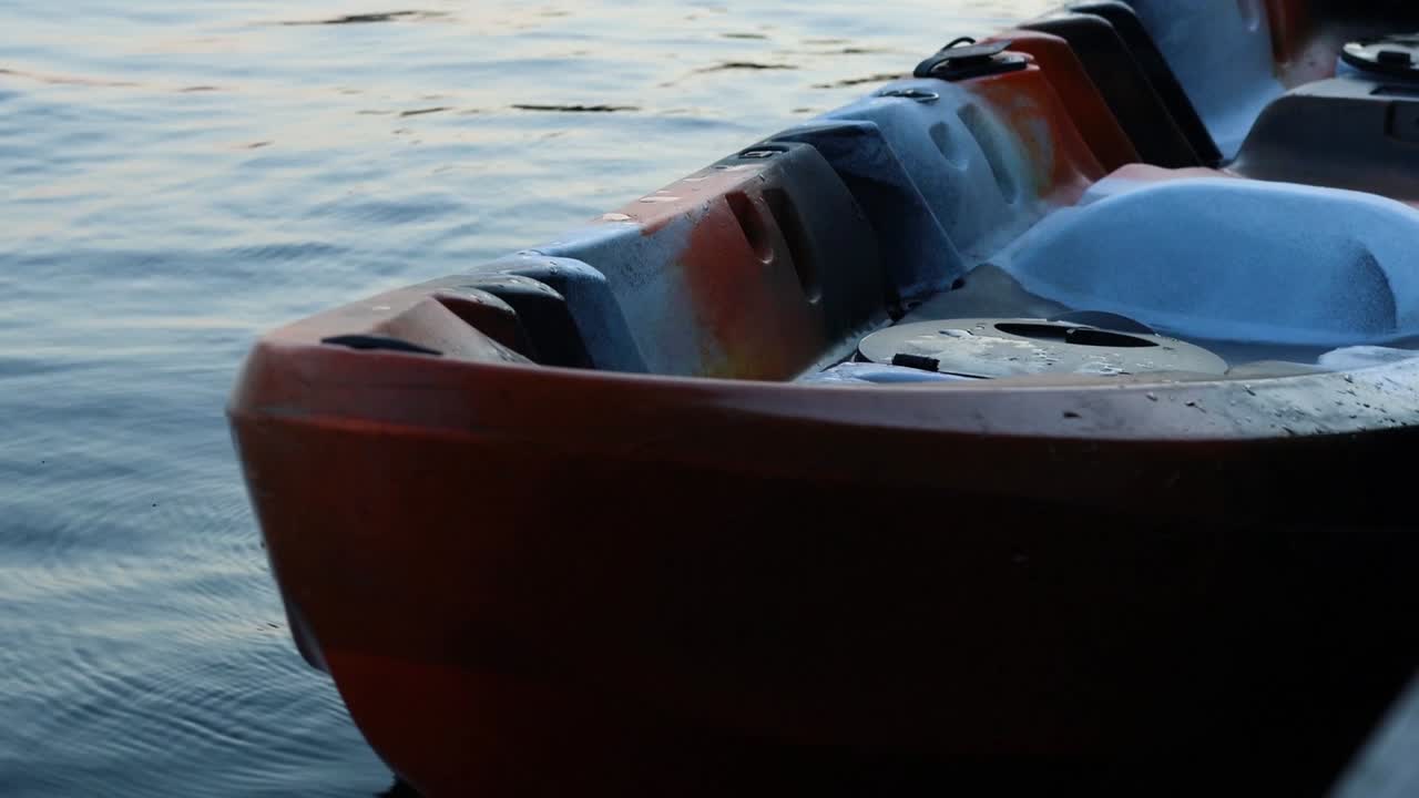 A detailed view of a kayak's interior and exterior against softly rippling water.
