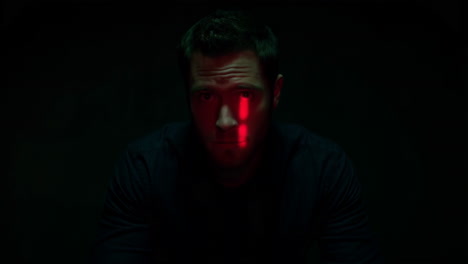 man in dark setting with red lighting and digital overlay