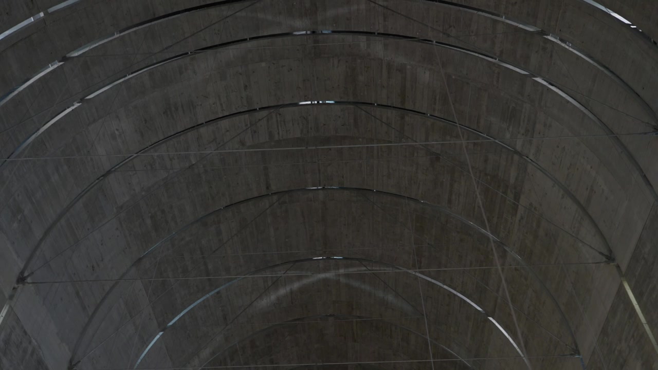 Curved concrete vaulted ceiling with arched lines in modern minimalist architecture interior