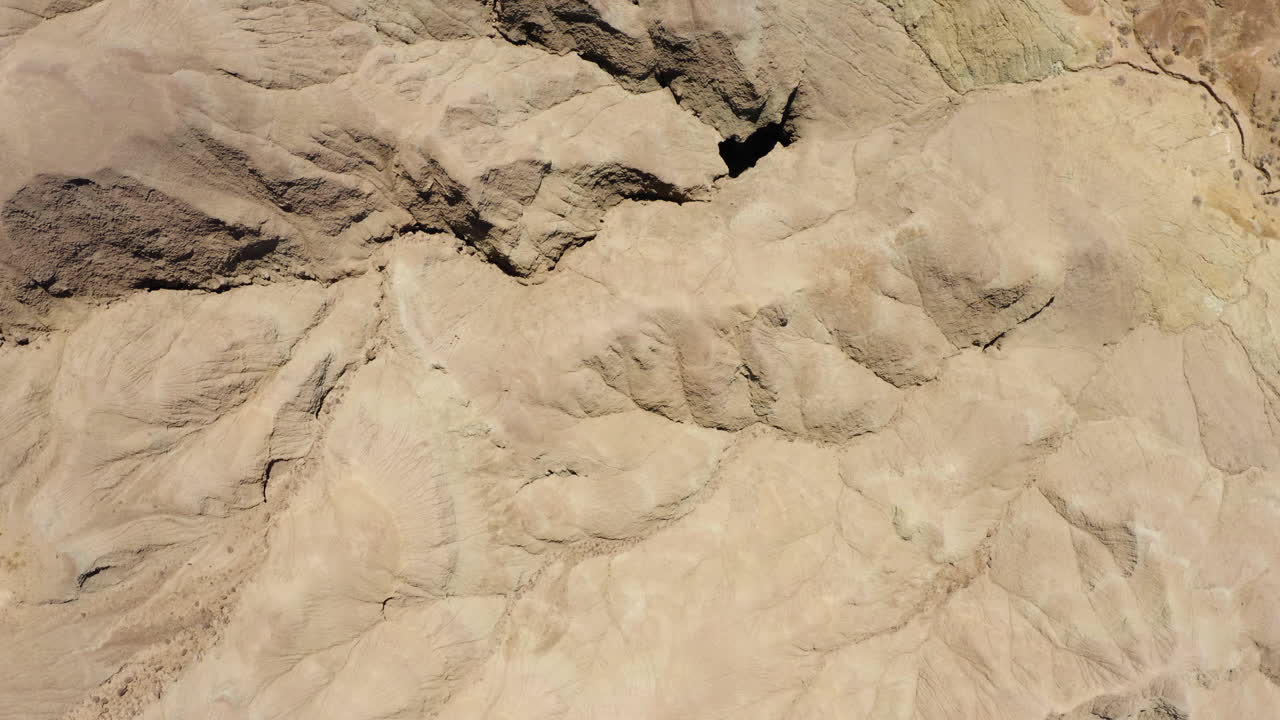 volando sobre el paisaje de textura arenosa en un ambiente desértico donde no hay plantas ni árboles