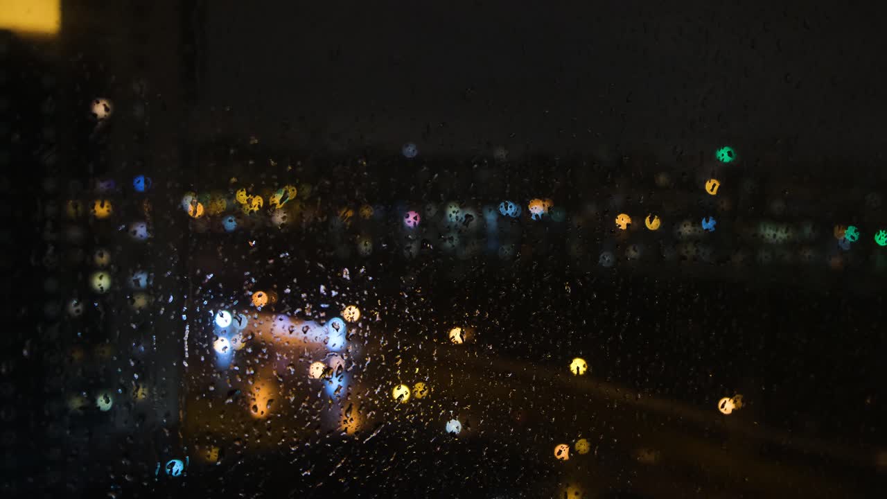 Rainy Night Cityscape View Through a Window