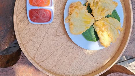 beautiful fried tempe a traditional indonesian local food and sauce on a round shape natural wooden tray with