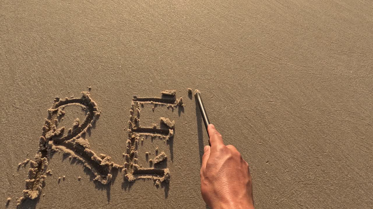 The word &amp;quot;Relax&amp;quot; written by hand on the beach sand, enjoying outdoor summer activity