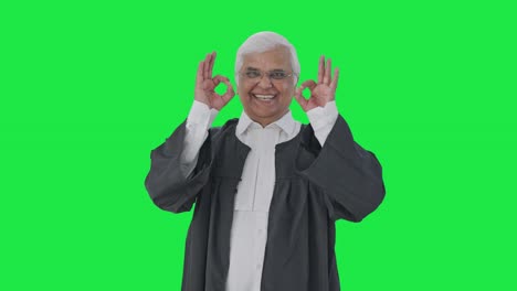 Happy-Indian-senior-lawyer-showing-okay-sign-Green-screen