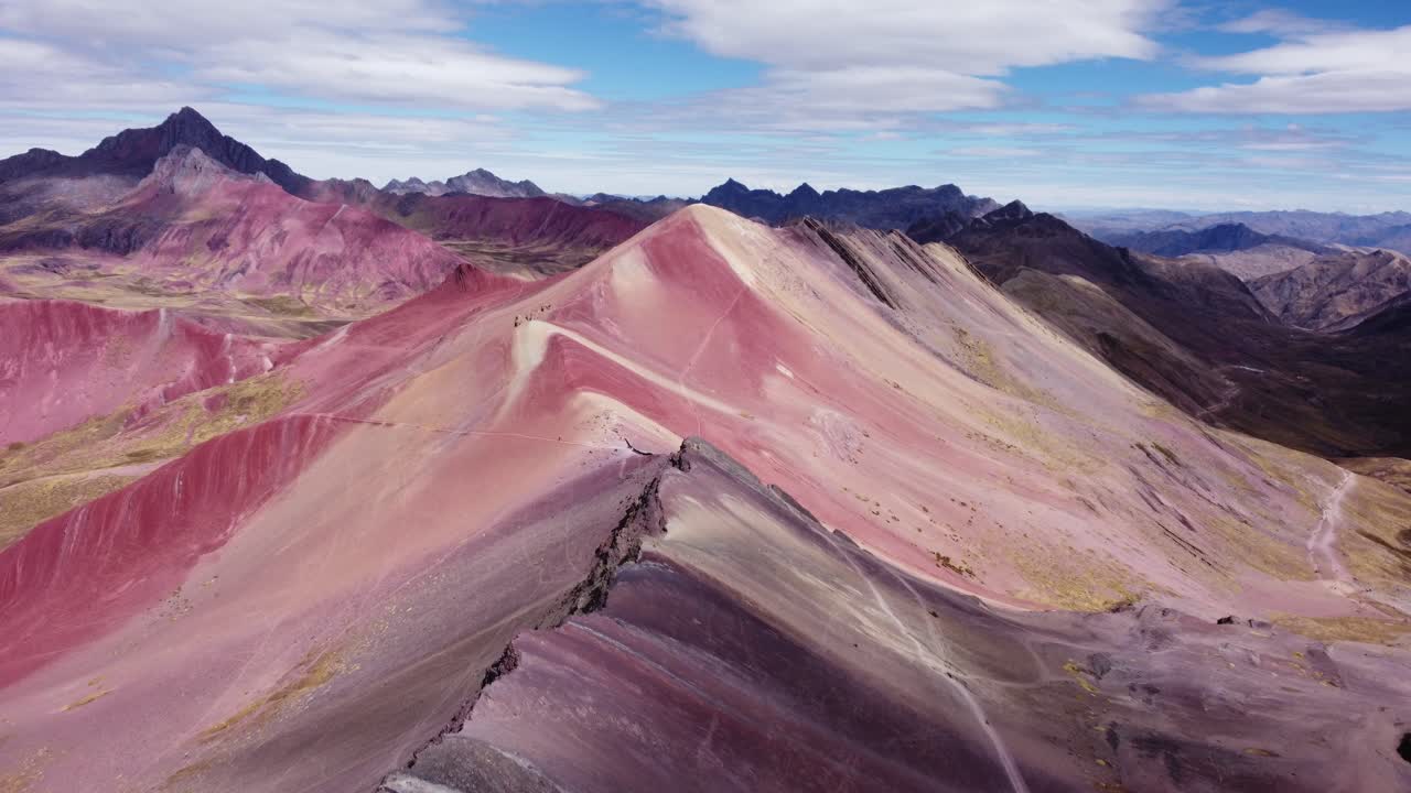 Ripresa aerea frontale di montagne con minerale rosso sulla montagna dei sette colori a Vinicunca