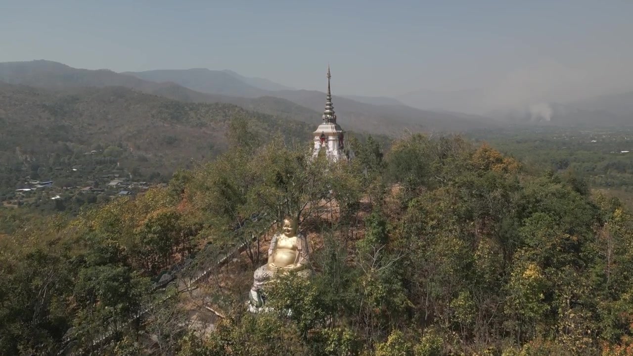 Prise de vue aérienne cinématographique par drone d'un temple en Thaïlande du Nord entouré de paysages pittoresques. Cadre culturel et spirituel paisible, idéal pour le contenu de voyage et de nature