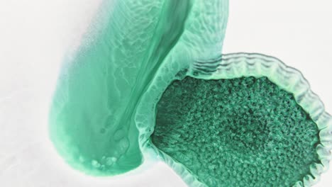 세포 모양의 가장자리와 함께 물에 녹색 잉크 구름, 생물학적 느낌을 주는 매크로