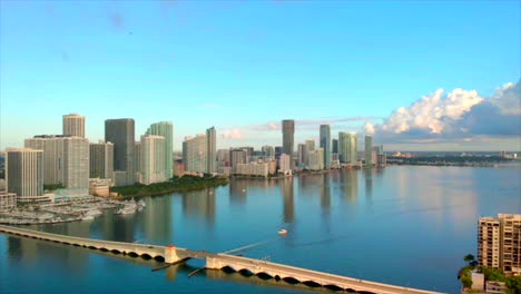 Toma-Aérea-De-4k-Del-Día-Del-Horizonte-De-Miami-Con-Puente-Y-Agua