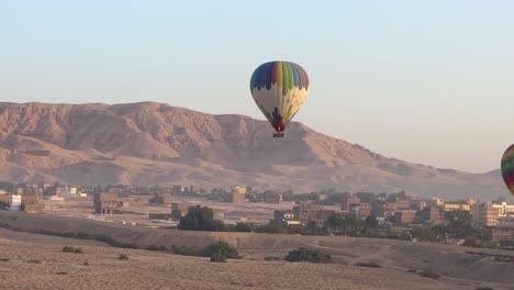 Fly-over-Luxor,-Valley-of-the-Kings-in-Egypt-in-a-Hot-Air-balloon-at-sunrise-overlooking-historical-sites