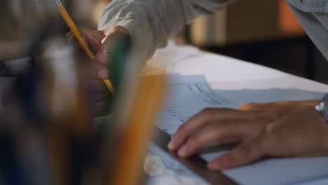 Close-Up-View-Of-Architect-Hands-Drawing-On-The-Plan-With-A-Pencil-And-Rule-On-The-Desk