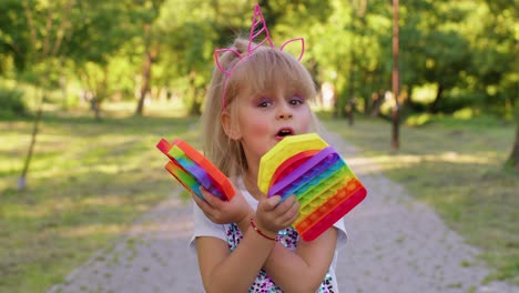 Niño-Pequeño-Y-Elegante,-Niña-Que-Muestra-Burbujas-Blandas-Con-Pantalla-Táctil-De-Silicona,-Juguetes-Sensoriales-Pop-It