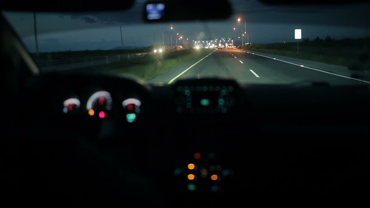 밤에 통행료 징수 지점에 있는 자동차