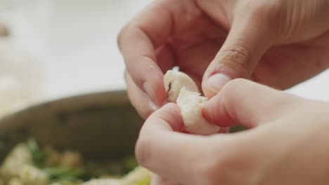 crop woman adding mozzarella balls to pasta