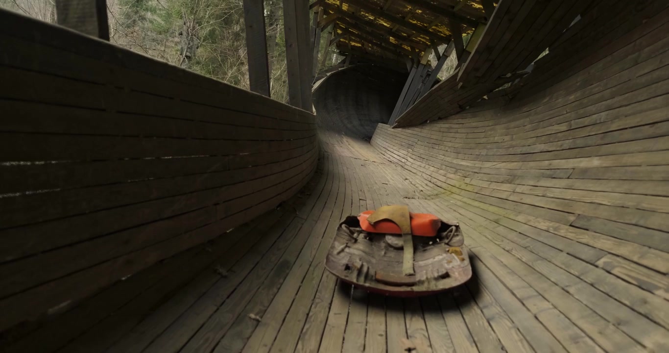 Una slitta da luge si trova su una vecchia pista da bob in legno in Lettonia.