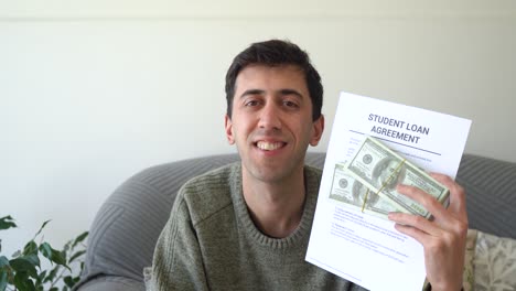 man showing his student loan agreement and the cash he got with it. concept of getting in debt to go to college