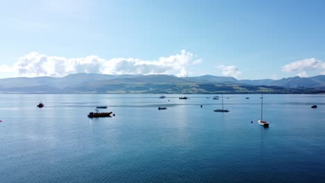 Snowdonia-Klare-Bergkette-Antenne-Push-Im-Blick-Sonnig-Ruhig-Walisisch-Schimmernde-Meereslandschaft