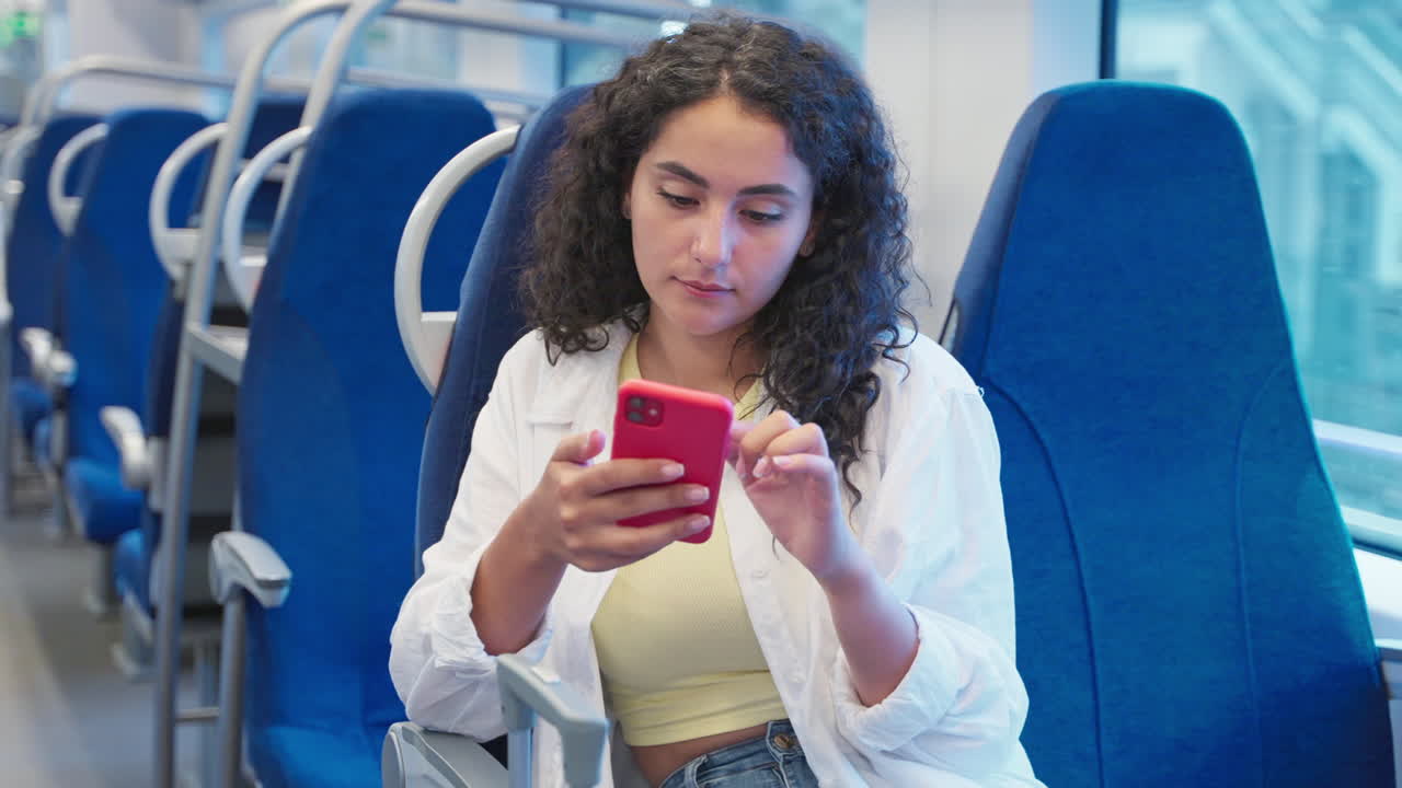 una mujer joven usando un teléfono inteligente en un tren