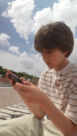 teenager using a smartphone on a rooftop