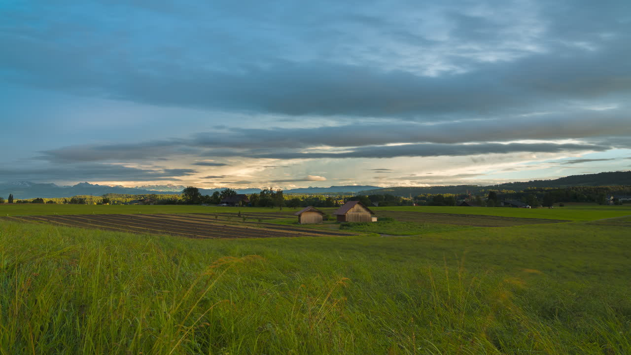 сельскохозяйственное поле с густыми облаками и закатом солнца