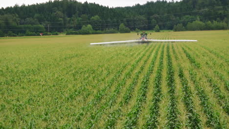 sprayer moving through corn field, applying crop protection