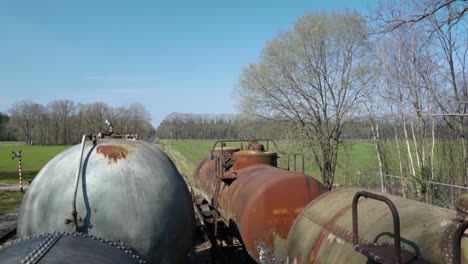 vagones cisterna de tren oxidados en el paisaje rural