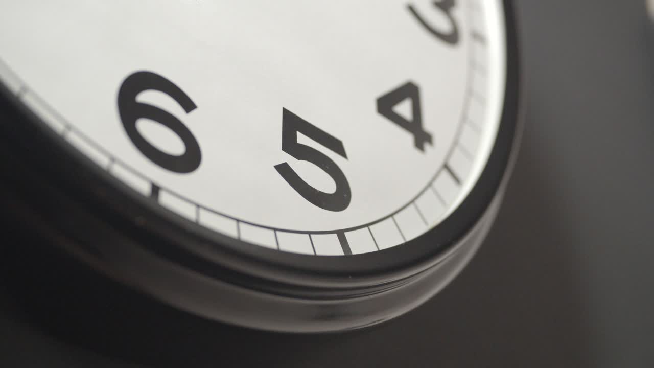 White Clock Face Close Up in Time Lapse on Dark Grey Wall