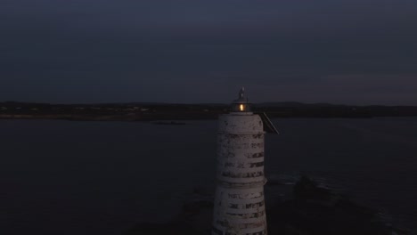 Drone-Aéreo-Dando-Vueltas-Alrededor-Del-Faro-Al-Anochecer,-La-Plataforma-Rodante-Revela-El-Cielo-Del-Anochecer