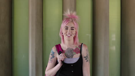 retrato de una mujer joven confiada, estudiante, tatuaje, perforación corporal, feliz.