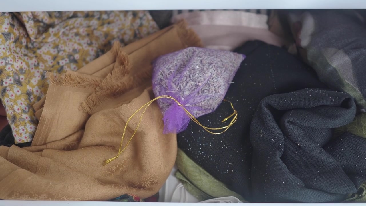 Hand Placing Lavender Sachet into Drawer with Clothes