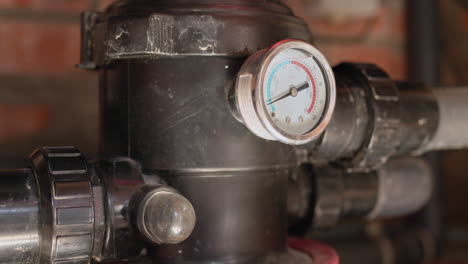 el funcionamiento del filtro de la piscina en modo de limpieza. en el marco se puede ver una ventana de visualización con una corriente de agua y escombros. el manómetro muestra la presión del agua. mantenimiento de la piscina