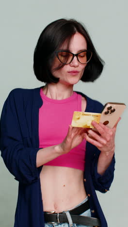 woman smiling holding credit card pointing to camera clearly indicating shopping payment gesture