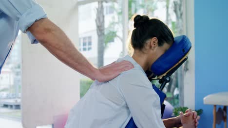 Male-physiotherapist-giving-back-massage-to-female-patient