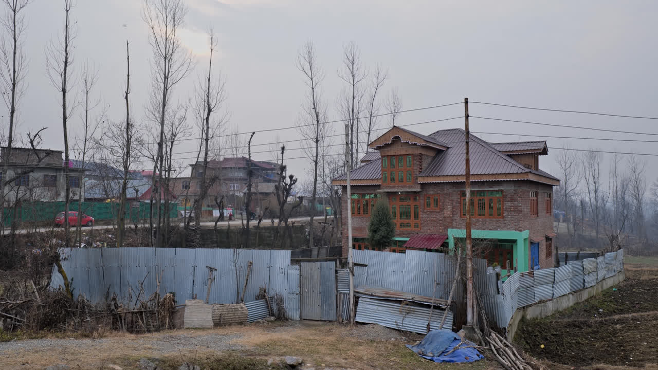 beautiful house and dead trees in the background during sun set at srinagar, jammu and kashmir, india, 4k push in shot
