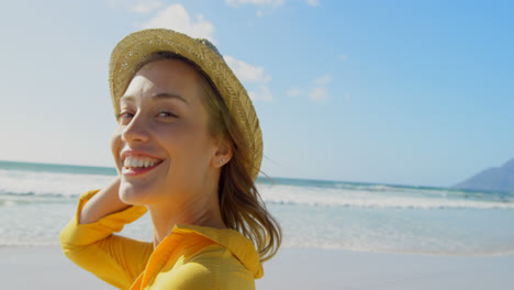 Seitenansicht-Einer-Jungen-Kaukasischen-Frau-Mit-Hut,-Die-Am-Strand-Steht-4k