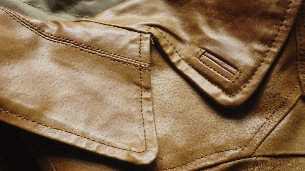 Eine detaillierte Nahaufnahme zeigt die exquisite Handwerkskunst und die Nähte einer Designer-Lederjacke. Perfekt für Luxusmode-Branding, Bekleidungsherstellung und Style-Inhalte.