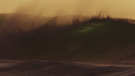 spray rises off top of lip as soft early morning light dances across waves as offshore winds pull ocean mist