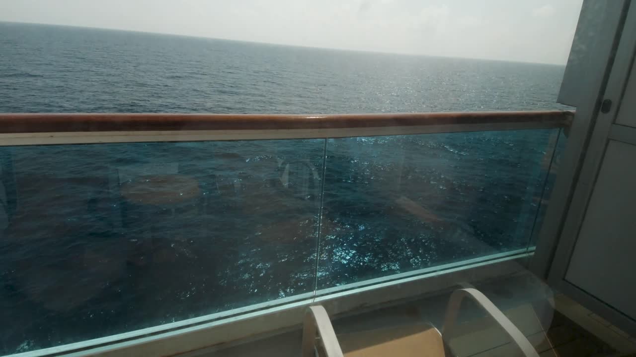 Balkonkabine eines italienischen Kreuzfahrtschiffes, schwenkt nach oben, um Meerblick mit Horizont zu enthüllen.