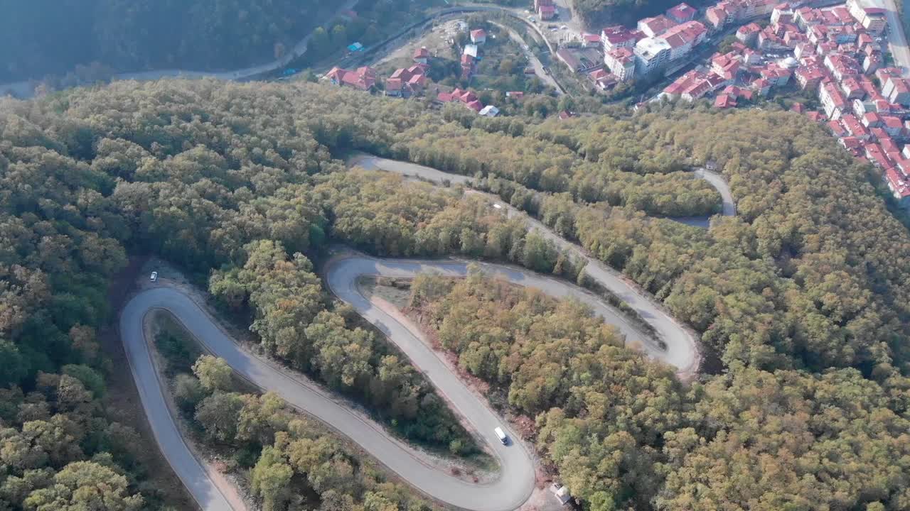 vista aérea de caminos forestales en zigzag en bartin con vehículos durante el día en la región del mar negro, turquía - tiro estático