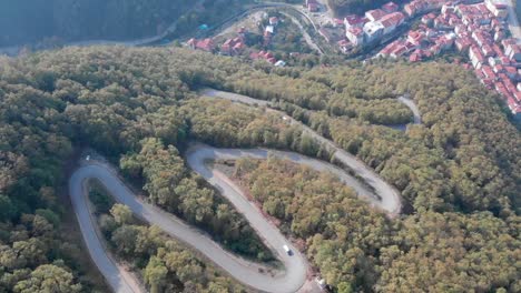 aerial view of zigzag forest roads in bartin with vehicles during day time in black sea region, turkey - static shot