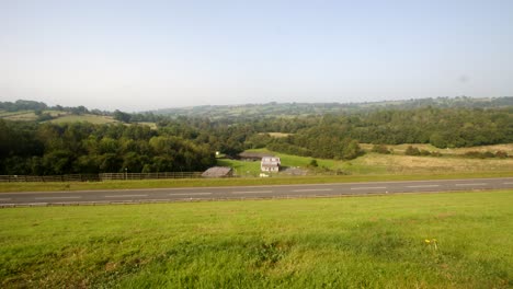 Extra-wide-shot-of-Carsington-Water-treatment-works-with-the-dam-road-foreground-with-cars-passing-through-frame