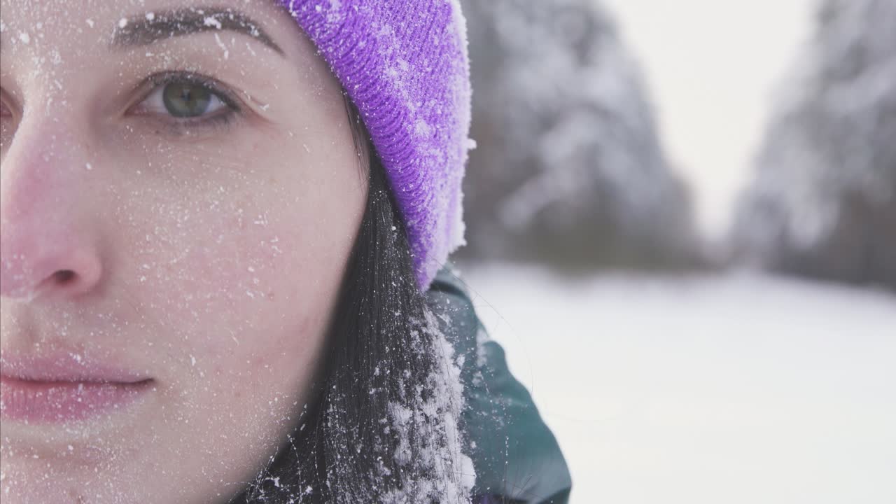 girl in the woods smiling looking at the camera, covered with snow after a snow storm is extremely