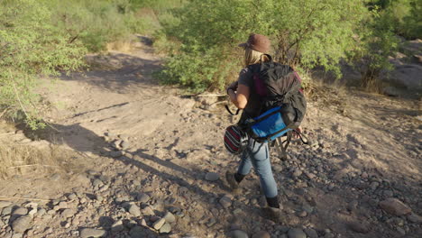 escalada en el desierto con una experimentada mujer caucásica con mochila